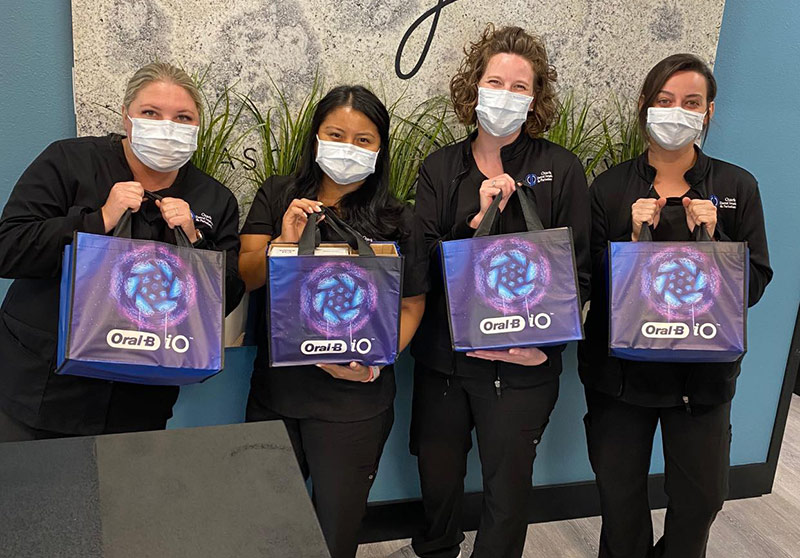 staff members holding Oral-B gift bags